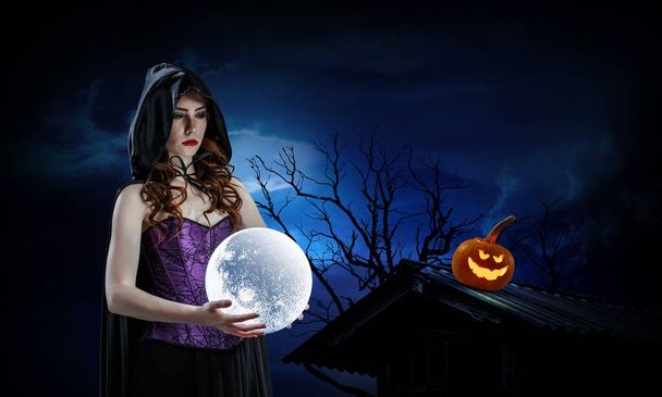 Piękna młoda kobieta w kapeluszu i kostiumie czarownicy. Projekt Halloween sztuki. Media mieszane - Zdjęcie, obraz