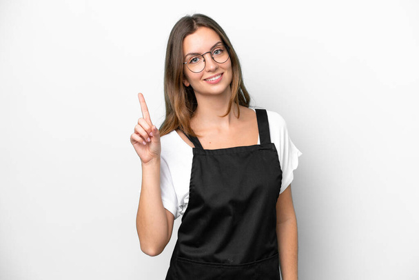 Young caucasian restaurant waiter woman isolated on white background showing and lifting a finger in sign of the best - Φωτογραφία, εικόνα