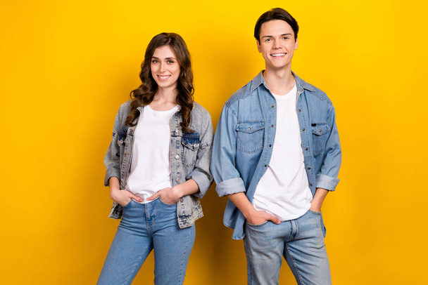 Photo of two cheerful friendly people toothy smile put hands pockets isolated on yellow color background. - Foto, imagen