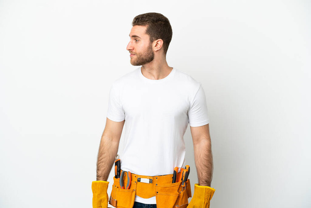 Young electrician man over isolated white wall looking to the side - Foto, afbeelding