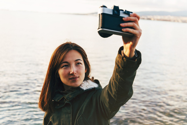 Woman takes self portrait on coastline - Foto, immagini