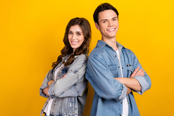 Photo of two cheerful nice people crossed hands beaming smile isolated on yellow color background. - Fotó, kép