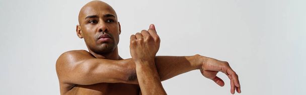 Sportsman with naked torso is warming up on white studio background - Foto, Imagen