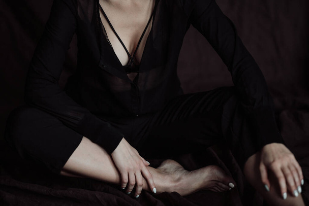 Volwassen schoonheid elegante jonge vrouw in formele avond zwarte kleding hand op gezicht aanraken. Stijlvolle gember krullend haar sensueel model kale schouder fashionista poseren in studio in fashion broekpak en beha - Foto, afbeelding