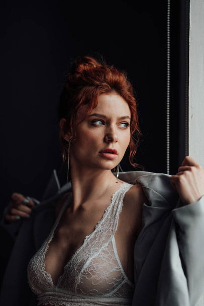 Adult beauty elegant young woman in formal evening gray suit with white bra at thoughtful. Stylish ginger curly hair sensual model bare shoulder fashionista posing at studio in fashion pantsuit - Zdjęcie, obraz