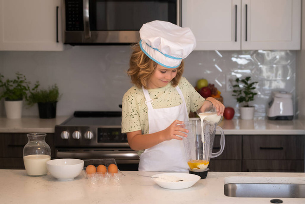 Engraçado cozinheiro miúdo cozinheiro vestindo uniforme cozinheiro cap e avental comida cozida na cozinha. As crianças estão preparando a massa, assar biscoitos na cozinha - Foto, Imagem