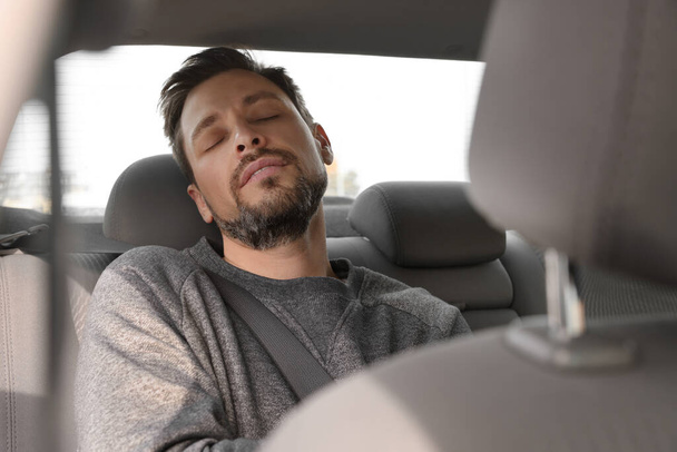 Tired handsome man sleeping in his car - Photo, image
