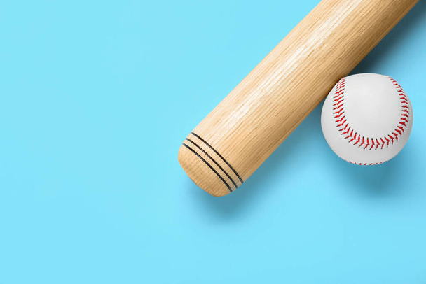 Wooden baseball bat and ball on light blue background, flat lay. Space for text - Fotó, kép