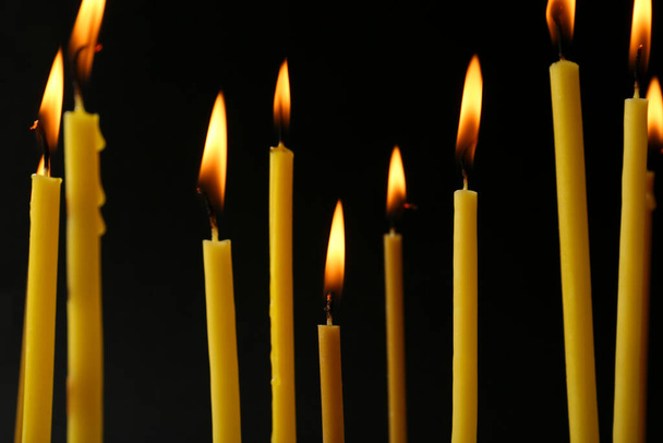 Many burning church candles on black background - Foto, Imagem