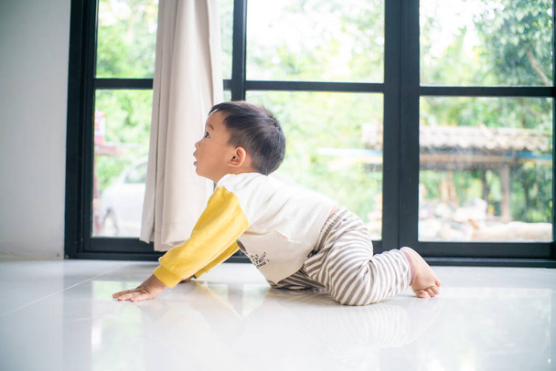 Maluch 1 rok chłopiec czołga się na podłodze domu praktyki chodzić - Zdjęcie, obraz