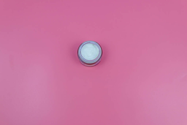 Face cream on a pastel pink background. Top view - Foto, afbeelding