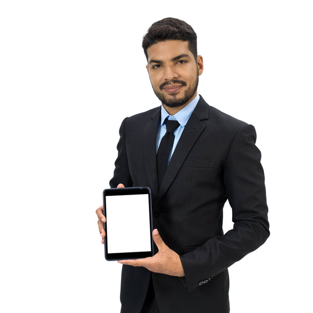 Young businessman with moustache and beard in black suit showing tablet computer with white screen. Portrait on white background with studio lighting. Isolated  - Fotoğraf, Görsel