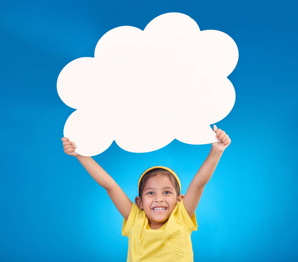 Speech bubble, thinking and portrait of child with idea, opinion and announcement on blue background studio. Talking, speaking mockup and excited, happy and young girl with smile, poster and banner. - Photo, Image