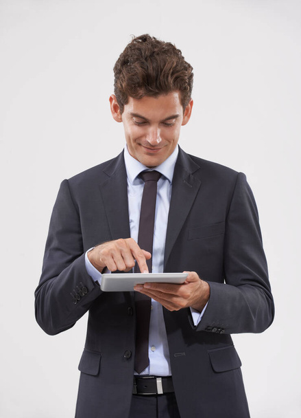 All my information is in the palm of my hands. a handsome young businessman using a digital tablet - Φωτογραφία, εικόνα