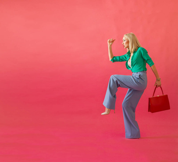 ピンクの背景で買い物に行く赤いハンドバッグとブロンドの女性,ショッピング,販売,黒の金曜日のコンセプト - 写真・画像