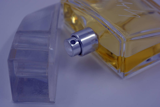 Жіночі стильні парфуми, пляшка парфумів у скляній пляшці зі свіжим яскравим ароматом і жовта рідина розташована на білому тлі
. - Фото, зображення