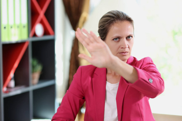 Žena ukazuje negativní gesto. Obchodní žena odmítá nabídky při sezení u kancelářského stolu. - Fotografie, Obrázek