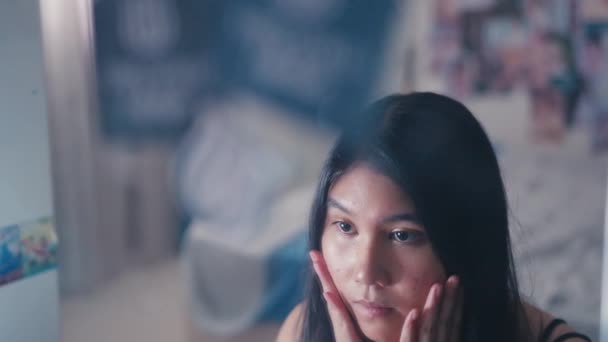 asijský teenager se podívá do zrcadla s pocitem nejistoty, protože její tvář je plná pupínků - Záběry, video
