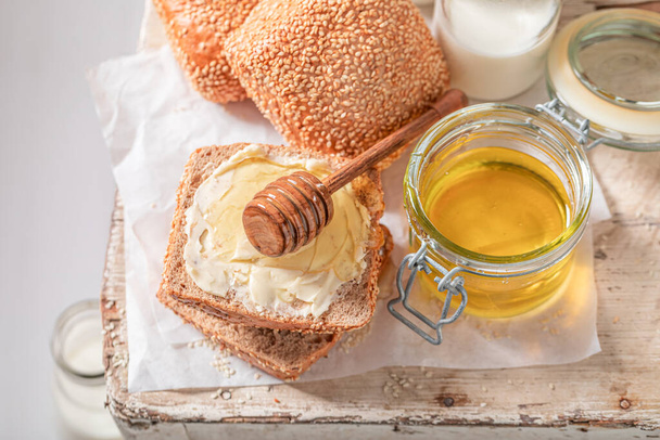Healthy buns with honey in the morning in farm. Breakfast with milk and honey. - Photo, image