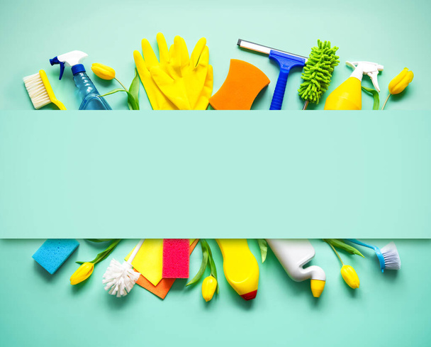 Flat lay composition with cleaning supplies, tools and spring flowers on colorful background. Top view with copy space - Photo, image