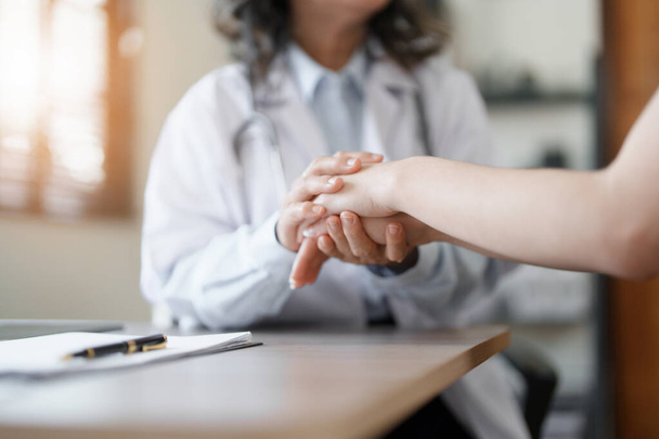 Retrato de una doctora sosteniendo la mano de un paciente para fomentar la lucha contra la enfermedad - Foto, imagen