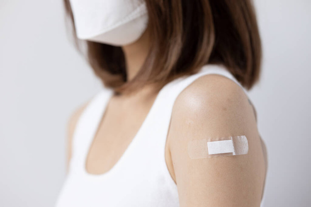 Vrouw met gezichtsmasker krijgt net vaccinatie. - Foto, afbeelding