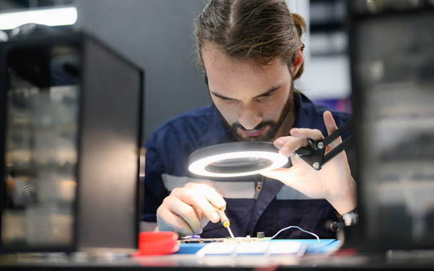 Professionelle Techniker prüfen und reparieren Teil der automatischen Maschine in der Industriefabrik - Foto, Bild