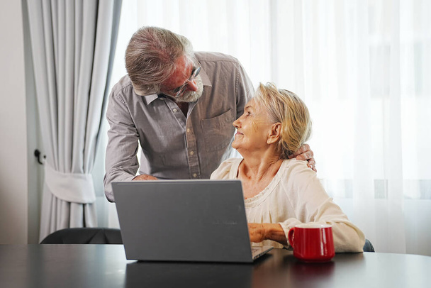 ηλικιωμένο ζευγάρι που χρησιμοποιεί φορητό υπολογιστή στο σπίτι - Φωτογραφία, εικόνα