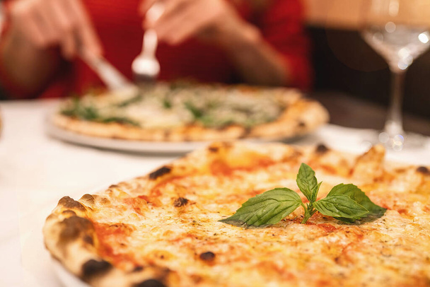 イタリアのフォークとナイフでマルゲリータ・ピザを食べる人は - 写真・画像