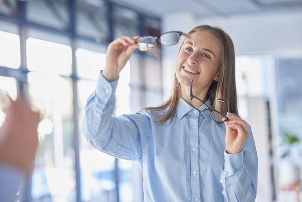 Bril, keuze en visie met een vrouw aan de optometrist voor nieuwe receptbril als klant. Oogkledij, beslissing en winkelen met een aantrekkelijke jonge vrouwelijke shopper die brillen koopt. - Foto, afbeelding