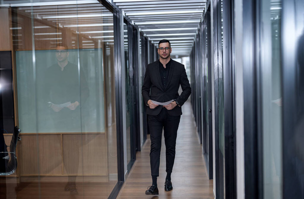 confident businessman walking in corridor - Фото, изображение