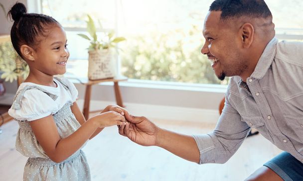 Black family, love and father dance with girl, having fun and bonding in home. Happy, smile and parent with child holding hands, dancing and playing, care and enjoying quality time together in house - Foto, Imagen