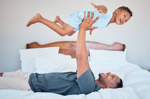 Happy, airplane and father with child in bedroom for relax, support and bonding together. Smile, balance and games with dad playing with son in family home for freedom, funny and affectionate. - Foto, afbeelding