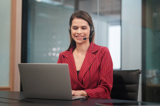 smiling businesswoman working with laptop in office - Φωτογραφία, εικόνα