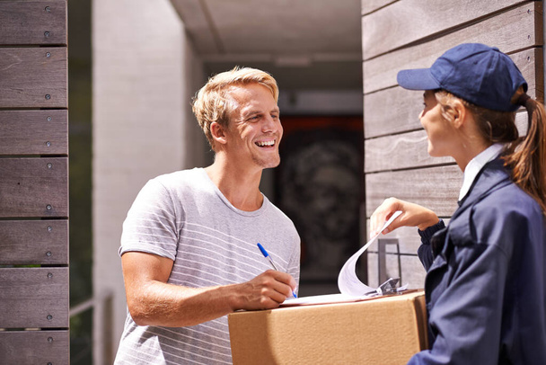 It always arrives on time. a courier making a delivery to a smiling customer - Foto, Imagem