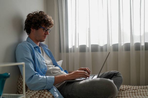 Homme utilisant un ordinateur portable travaillant à la maison, Homme d'affaires heureux utilisant un ordinateur portable envoyant des e-mails travaillant à la maison, Freelance dactylographier sur ordinateur portable avec des papiers et des documents - Photo, image