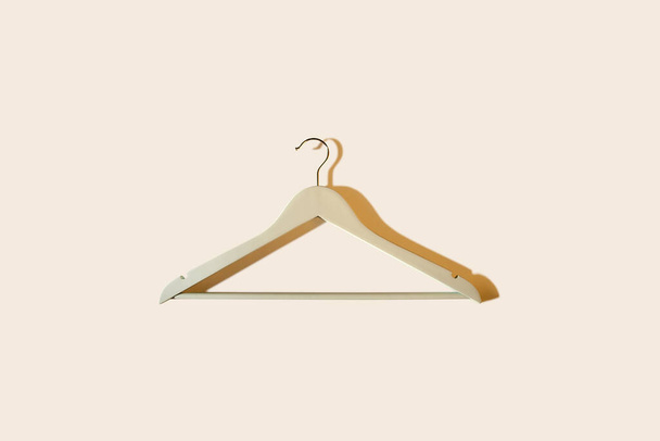 Coat hanger on pastel background with shadows. Space for text. Sale banner concept - Photo, Image