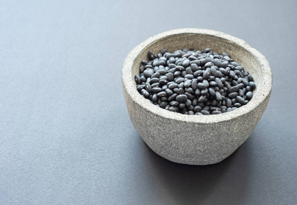 black peas in a grey pot on a grey blackground - Photo, Image