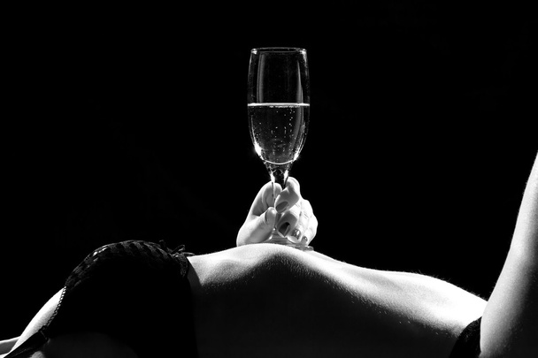 Black and white photo of woman's body with glass - Photo, Image