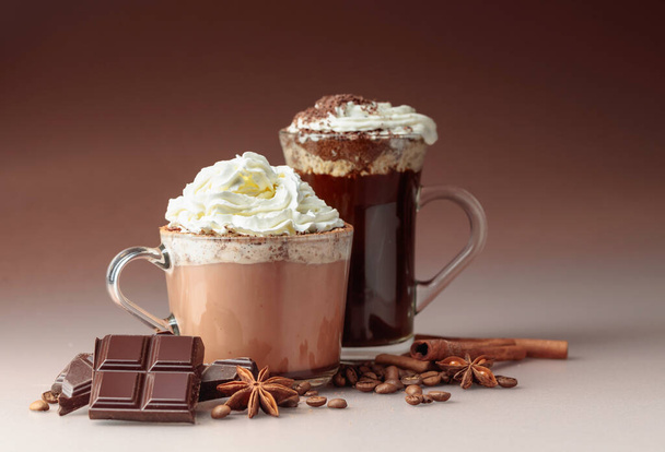 Gorąca czekolada i kawa z bitą śmietaną posypane okruszkami czekolady. Gorące napoje wakacyjne ze składnikami. - Zdjęcie, obraz