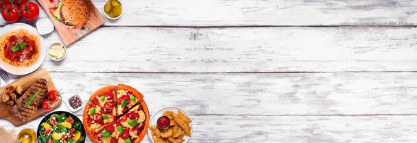 Corner border of a variety of delicious foods. Above view on a white wood banner background. Copy space. - Photo, Image