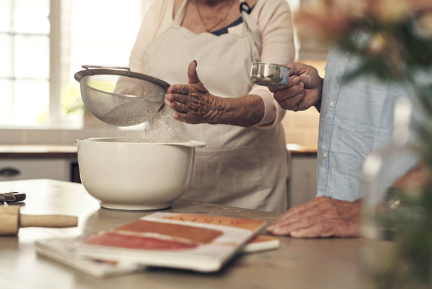 I always have help by my side. Shot of an unrecognizable couple baking together at home - Fotografie, Obrázek