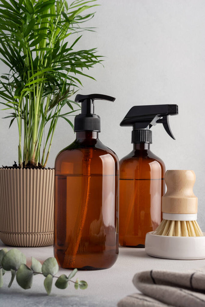 Eco friendly kitchen concept, sustainable lifestyle. Set for cleaning, as dish wash brush, spray bottle, dispenser with home plant and towel - Photo, Image