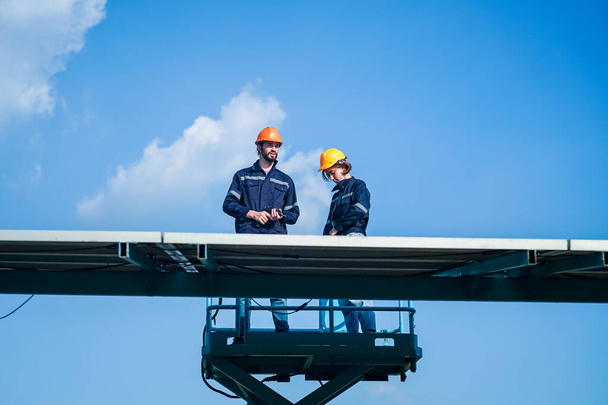 Technologia ogniwa słonecznego, Inżynier serwisowy sprawdzenie instalacji ogniwa słonecznego na dachu fabryki. technik sprawdza konserwację paneli słonecznych - Zdjęcie, obraz
