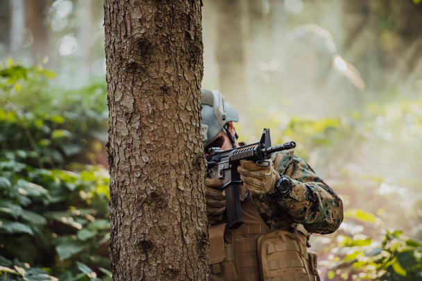 A modern warfare soldier on war duty in dense and dangerous forest areas. Dangerous military rescue operations. - Photo, image