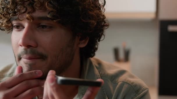 Κοντινό πλάνο Indian Man κρατώντας smartphone καλώντας χρησιμοποιώντας το τηλέφωνο ομιλητής μιλώντας με φίλο μιλήσει στο κινητό μεγάφωνο άνεση χρήση. Αραβας επιχειρηματίας ηχογράφηση φωνητικό μήνυμα φωνητικό μήνυμα στην κουζίνα - Πλάνα, βίντεο