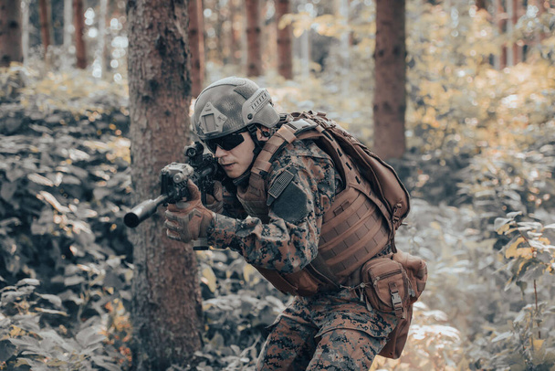 A modern warfare soldier on war duty in dense and dangerous forest areas. Dangerous military rescue operations. - Fotó, kép