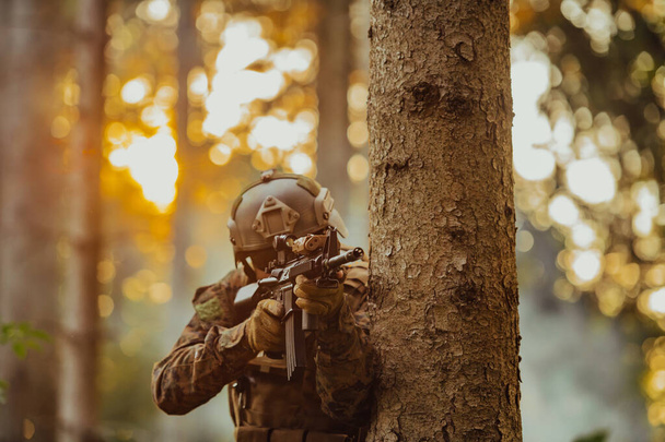 A modern warfare soldier on war duty in dense and dangerous forest areas. Dangerous military rescue operations. - Фото, изображение
