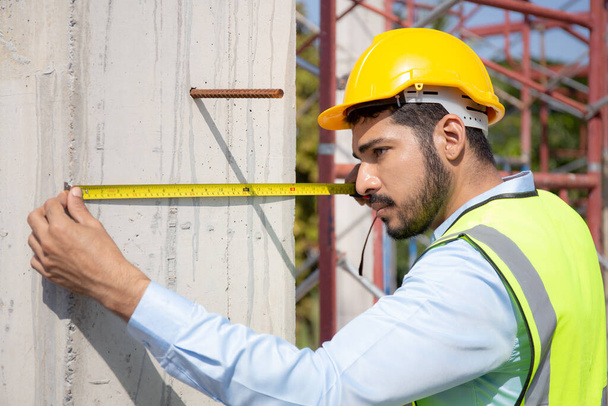 Engineer young man using tape measure for check and examining length of structure with professional at construction site, architect inspection and improvement infrastructure, industry concept. - Fotó, kép