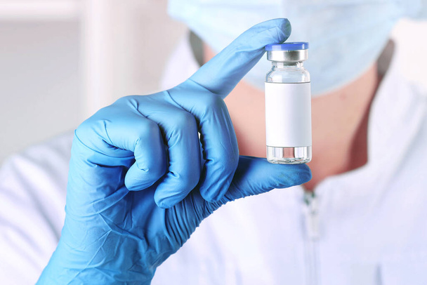 Laboratory worker holding glass vial with medication in hospital, closeup - Foto, Bild